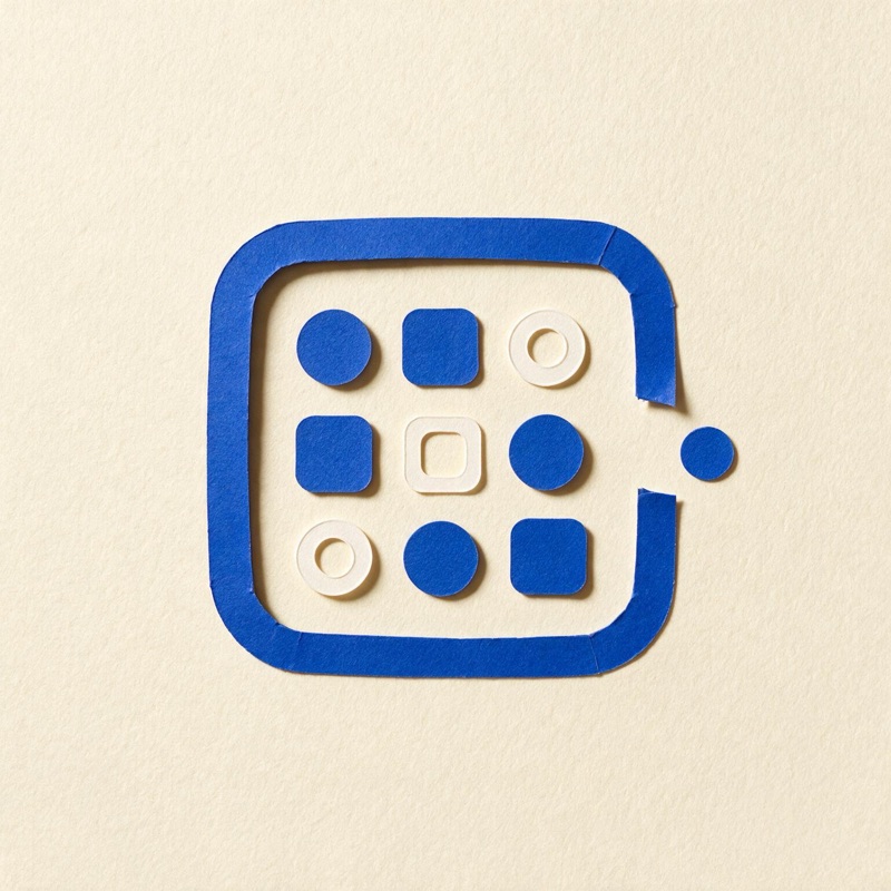Paper shapes arranged inside a blue frame, one circle entering through a gap