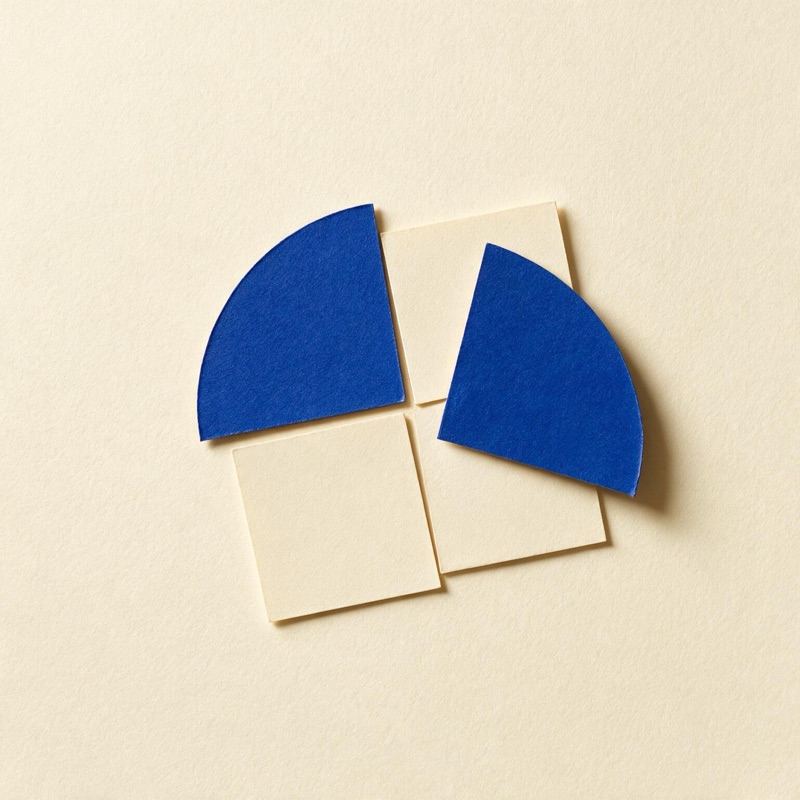 Paper quarter circles and squares interlocking into one larger square