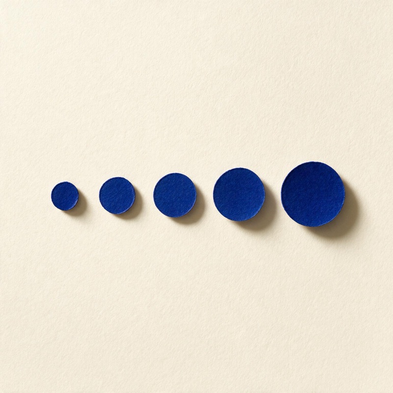 Five blue paper circles increasing in size, like a spacing scale